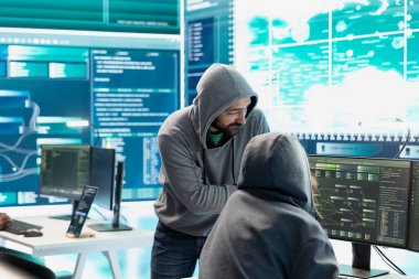 Bir hükümet güvenlik operasyonları merkezinde çalışan profesyonel bilişim uzmanı büyük ekrandaki verileri analiz ediyor. Siber güvenlik izleme ve tehdit analizinin önemini vurgulamak.