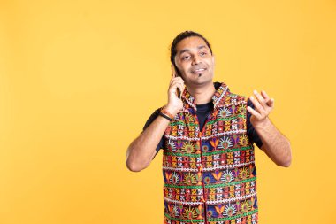 Neşeli adam telefonda en iyi arkadaşıyla tartışıyor, boş zamanların tadını çıkarıyor. Keyifli bir insan Hint kıyafeti giyer telefon görüşmesinde arkadaşıyla konuşur, stüdyo arka planında izole olur.