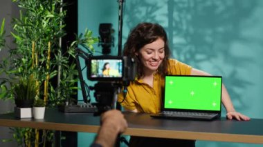 İzleyiciler tarafından istenen internet videolarını izleyen bir kadın. Çevrimiçi etkileyici aboneler tarafından gönderilen çevrimiçi videolara tepki veriyor yeşil ekran not defteri, kamera A