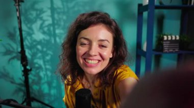 Canlı yayını ve aboneleri selamlamak için el kamerasını kullanarak ev stüdyosunun neşesini yerine getiriyor. Mutlu internet şovu sunucusunun görüntüsü izleyicilerle ev turu yapıyor.