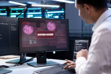 Sunucu merkezindeki yönetici, donanımı bilgisayar korsanlarının hassas bilgileri çalmasından korumaya çalışıyor. Veri Merkezi çalışanı monitörde güvenlik ihlali uyarısı gördükten sonra virüsü silmeye çalışıyor