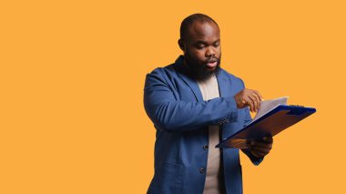 Panodaki mali denetim raporlarına göz atan bir adam yüksek gelirli, stüdyo geçmişinden memnun. Mutlu Afro-Amerikan işçileri not defterinde kağıt okuyorlar, rakamlardan tatmin oluyorlar, kamera B