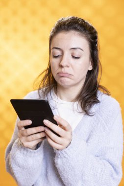 Okurken suratını asan, boş zamanlarında hobilerinden zevk alan bir kadın. Elinde tablet olan kişi kasvetli, dijital romandaki karakter ölümü, stüdyo geçmişi...