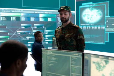 İleri teknoloji ve büyük ekran kullanarak gözetleme ve casusluk faaliyetleri yürüten askeri bilişim uzmanları. Siber tehditlere ve dijital paralı askerlere karşı korunan devlet dairesi.