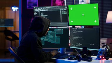 Hacker coding on isolated screen computer monitors, developing zero day exploit undetectable by antivirus. Evil IT engineer using chroma key PC displays to build script tricking firewalls, camera A clipart