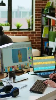 Dikey Video Yaratıcı kadın, grafik tasarım endüstrisinde üretkenliği artırmak için dijital araçlar kullanarak, teknoloji güdümlü bir çalışma alanında bilgisayarındaki fotoğraf düzenleme ve tasarım projelerini yönetir. Kamera A