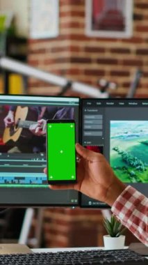 Dikey Video Erkek video düzenleyici, çift monitör ve teknik araçlar kullanılarak zaman çizgisi düzenleme ve renk derecelendirme arasında birden fazla görev içeren kroma tuşunun yanındaki yaratıcı bir yazılımda bir film projesinde çalışır. Kamera.