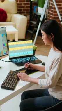 Vertical Video Freelance tasarımcısı, gelişmiş tasarım yazılımı kullanılarak uzak bir ofiste bir fotoğraf düzenleme projesi üzerinde çalışır. Ev işleri, yaratıcılığı ve online çalışmalar için yeniliği teşvik eder. Kamera A.