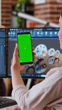 Dikey Videolu Asyalı bağımsız geliştirici kulaklıklar ve krom anahtar ekranla çalışarak imalat endüstrisi için yeni bir prototip yaratıyor. Kadın 3D model mühendisi ev ofisinde. Kamera B.