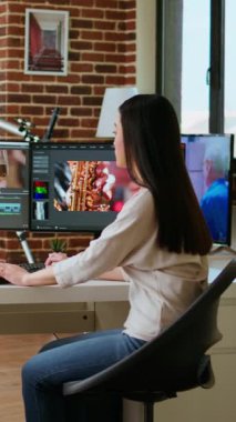 Dikey Video Freelancer Asyalı kadın video yapımcısı bir film projesinde çalışıyor, çift monitörlü çoklu görev, kurgu yazılımı ve çalışma alanında renk çarkı. Film kurgu endüstrisi. Kamera A