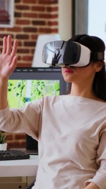 Sanal gerçeklik gözlüğü kullanan ve video kliplerini karıştıran dikey video Asyalı modern editör, bir montaj için renk derecelendirme ve düzenleme yapmak için interaktif cihaz vr kulaklığı kullanıyor. Video düzenleme yazılımı. Kamera.