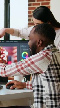 Modern yazılım kullanılarak post prodüksiyonda video klipleri düzenlemek ve karıştırmak için bağımsız bir video çekiminde takım olarak çalışan dikey Video Çeşitliliği karışık ırk çifti. Çok ırklı insanlar uzaktan iş yapar.