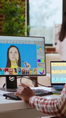 Dikey Video Freelance grafik tasarımcısı uzak bir ofisteki modern bir bilgisayar kurulumunda fotoğraf düzenliyor. Dijital tasarım uzmanı için ideal çalışma alanı. Dijital resimlerin rötuşlanması. Kamera.