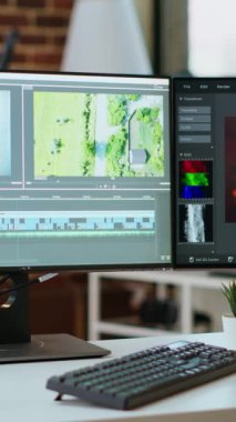 Bir video düzenleme zaman çizelgesi ve renk derecelendirme araçları gösteren çift monitörlü dikey video boş modern ofis çalışma alanı. Video üzerinde uzaktan çalışan sinemacılar ve medya yaratıcıları için mükemmel.
