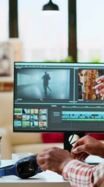 Dikey Afrikalı Afrikalı Amerikalı film yapımcısı profesyonel bir video çekiminde çalışıyor, bir video projesinin düzenleme zaman çizelgesini yönetiyor. Modern kurgu araçları ve renk derecelendirme yazılımı çalıştırılıyor. Kamera B