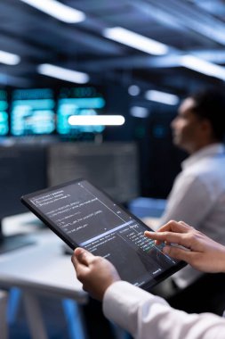 Sunucu merkezindeki bilgisayar bilimcisi, performansı etkileyen güvenlik duvarı yanlış yapılandırmalarını bulmak için tablet kullanıyor. Bilgi İşlem personeli, veri aktarım hızlarının düşmesine yol açan sistemleri kontrol ediyor, kapatıyor