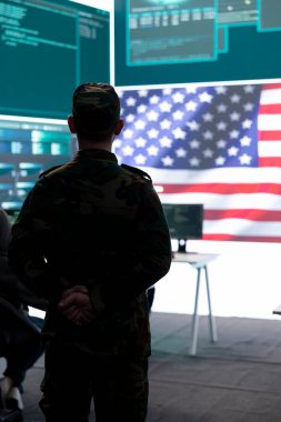 American military personnel supervising cyber warfare activity in high tech office, examine top secret intelligence on big screen. Governmental experts manage hybrid war, digital conflict prevention. clipart