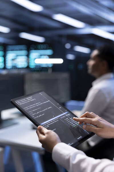 Computer scientist in server hub using tablet to find firewall misconfigurations affecting performance. IT staff member checking systems bottlenecks leading to sluggish data transfer rates, close up