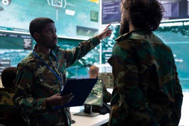 Askerler, askeri karargahta federal bir kontrol merkezinden barışı sağlayacak yeni bir ulusal güvenlik programı sağlıyor. Askerler güvenlik kameralarının uydu sistemini, ordu bölümünü inceliyor..