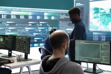 Hükümet hackerları ağ güvenliğini gelişmiş tekniklerle ve siber savunmayla aşıyor. Bilgi toplamak için bilgi toplamaya çalışan bilişim uzmanları ekibi, büyük ekran.