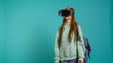 Sanal gerçeklik kulaklığı takan, el kol hareketleri yapan bir kadın. Teknoloji meraklısı ileri teknoloji modern VR aygıtı kullanıyor, stüdyo arka planında izole edilmiş, kamera B