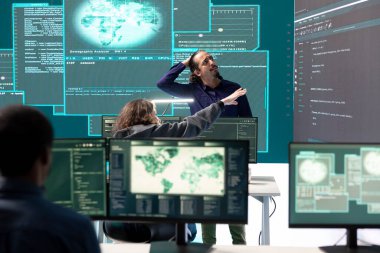 Melez savaşı sırasında dijital güvenlik faaliyetleri üzerinde çalışan hükümet hackerlarıyla birlikte siber operasyonlar merkezi. Uzmanlar güvenlik ve zararlı yazılım tespiti ve siber gözetim sağlıyorlar..