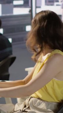 Tekerlekli sandalyedeki dikey video yöneticisi hataları en aza indirmek için çalışan test makinesi öğrenme yazılımının yanından geçiyor. Kadın işçileri kapsayan bir çalışma alanında çalışıyor.