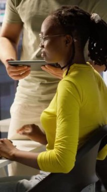 Dikey Video Yöneticisi, ofis masası çalışanlarını kontrol etmeye geliyor. Program ve sistemleri test ediyor. Ekip lideri, geliştiricinin çalışma alanındaki bilgisayarda kod yazmasını denetliyor, kamera A