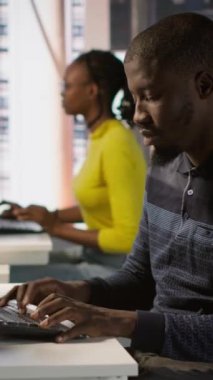 Vertical video programcısı yazılım hata ayıklama yapıyor, tekerlekli sandalyedeki gülümseyen takım liderinden yardım istiyor. Çalışan kodlama hatalarını düzeltir, engelli neşeli yönetici ve kamera tarafından yardım edilir.