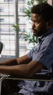 Dikey video yazılım teknisyeni. Engelli iş yerinde makine öğrenme teknolojisiyle çalışıyor. Tekerlekli sandalyedeki belden aşağısı felçli Afrikalı Amerikalı bilişim uzmanı verileri öngörücü hale getiriyor.