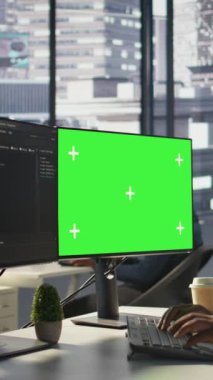 Dikey video programcısı, makine öğrenme modellerini eğitmek ve görüntüyü yakınlaştırmak için yeşil ekran bilgisayar kullanıyor. IT uzmanı tarafından kullanılan modelleme bilgisayarının kapatılması ve şirket sistemlerinin korunması, kamera B