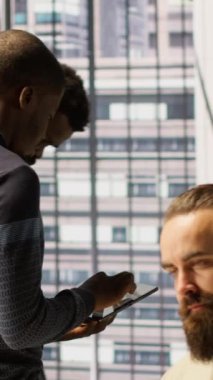 Dikey video teknisyeni ve meslektaşı bulut hesaplama platformlarını çalıştırmak için cihaz kullanıyor eğitim makineleri öğrenme modelleri. Ofisteki bilişim personeli şirket sistemlerini tablet, kamera kullanarak izliyor