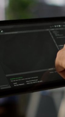 Dikey video veri bilimcisi, karar verme süreçlerini otomatik hale getirmek için verileri analiz edebilen makine öğrenme modellerini kontrol etmek için tablet kullanıyor. Programlama yapmak için aygıt kullanan bilişim uzmanını kapat