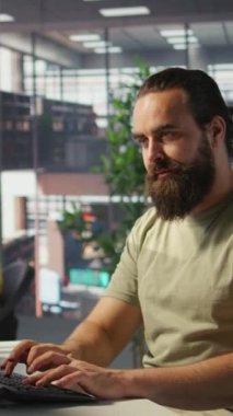 Dikey video çalışanı bilgisayar monitörüne bakıyor, kahve içiyor, iş sezgileri bulmak ve projeyi bitirmek için gerekli verileri kontrol ediyor. Bilgisayarda veri analiz eden, içecekten zevk alan, kamera