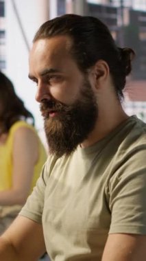 Dikey video çalışanı bilgisayar monitörüne bakıyor, kahve içiyor, iş sezgileri bulmak ve projeyi bitirmek için gerekli verileri kontrol ediyor. Bilgisayarda veri analiz eden, içecekten zevk alan, kamera
