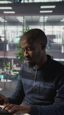 Vertical video programcısı yazılım hata ayıklama yapıyor, tekerlekli sandalyedeki gülümseyen takım liderinden yardım istiyor. Çalışan kodlama hatalarını düzeltir, engelli neşeli yönetici ve kamera tarafından yardım edilir.