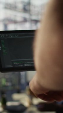 Dikey video veri bilimcisi, karar verme süreçlerini otomatik hale getirmek için verileri analiz edebilen makine öğrenme modellerini kontrol etmek için tablet kullanıyor. Programlama yapmak için aygıt kullanan bilişim uzmanını kapat
