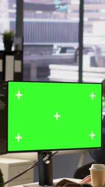Yeşil ekranda yazılım hata ayıklaması yapan dikey video yöneticisi, iş arkadaşından yardım istiyor, kod hatalarını kontrol ediyor. İşçi, meslektaşı tarafından desteklenen, model bilgisayardaki kodlama hatalarını düzelten