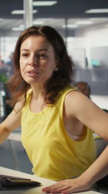 Dikey video işçisi mesai sırasında bilgisayar kullanarak ofis masasında oturuyor, bilgi almak için yönetici tarafından engelleniyor. Çalışma alanında çalışan bir şirket çalışanı, görevlerini yapıyor, geri bildirimlerini dinliyor.