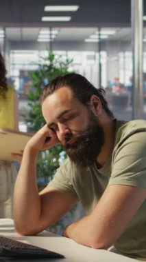 Dikey video Yorgun Geliştirici AI makine öğrenme teknolojisini geliştirirken yönetici tarafından masada uykuya daldı. Yönetici, öngörü modellerini eğitirken yorgun uyuyan bir çalışanı uyandırıyor