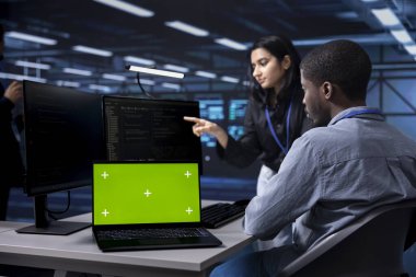 Admins using mockup laptop to reconfigure server room facility, optimizing it for data processing requirements. Workers using green screen notebook, ensuring data center tech operates efficiently clipart