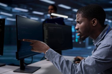 Server hub technician frowning, confused by errors on screen while shielding data from potential threats. Surprised african american man puzzled by malfunctions on data center hardware clipart