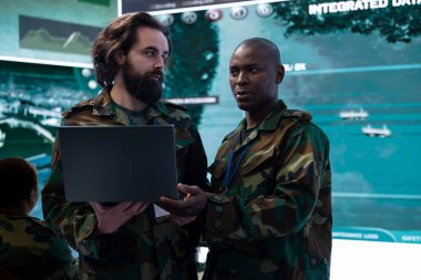 Bilgisayardan büyük ekrana gerçek zamanlı savaş alanı verilerini karşılaştıran çeşitli bilişim operatörleri gelecekteki saha görevleri için istihbarat topluyor. CCTV uydu görüntülerinden bilgi topluyorum..