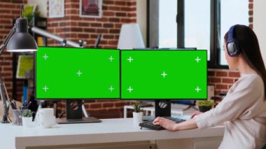 Asyalı serbest çalışan biri, evde araştırma yaparken, bilgisayar ekranında yeşil ekranla görevleri üzerinde çalışıyor, kulaklıkla müzik dinliyor. Serbest çalışma, birden fazla iş, uzaktan kumanda. Kamera B.