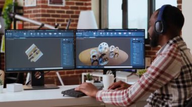 Afrika kökenli Amerikalı endüstriyel tasarımcı CAD yazılımında çalışıyor ve evde müzik dinliyor, birden fazla iş yapıyor. Mühendis endüstriyel projeler için dijital aletler ve 3D modelleme kullanıyor. Kamera B.