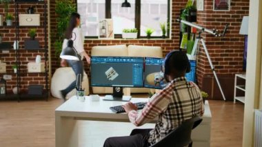 Afrika kökenli Amerikalı endüstriyel tasarımcı CAD yazılımında çalışıyor ve evde müzik dinliyor, birden fazla iş yapıyor. Mühendis endüstriyel projeler için dijital aletler ve 3D modelleme kullanıyor. Kamera A.