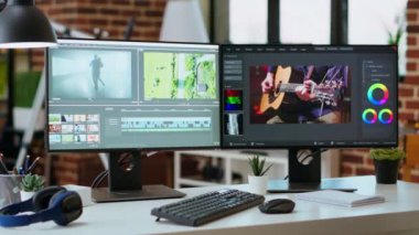 Video düzenleme zaman çizelgesi ve renk derecelendirme araçlarını gösteren çift monitörlü boş modern ofis çalışma alanı. Video projeleri üzerinde çalışan film yapımcıları ve medya yaratıcıları için mükemmel..