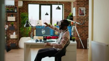 Sanal gerçeklik kulaklığı ve yapay zekayla çalışan Afrikalı Amerikalı yazılım geliştirici CAD yazılımında yeni endüstriyel prototipler ve üretim araçları yaratmak için çalışıyor. Kamera A.