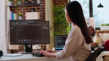 Asyalı kadın geliştirici modern bir teknoloji çalışma alanında bilgisayar programları kodluyor. Kadın bilişim uzmanı, üretkenlik ve yenilik için yazılım geliştirme sürecine odaklanıyor. Kamera B.