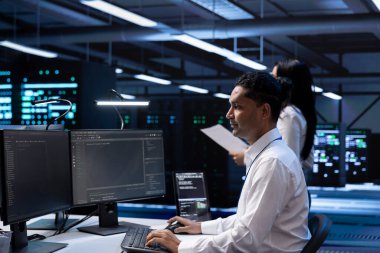 Donanım güncellemesinden sonra veri merkezindeki sistem yöneticisi bilgisayardaki ekipman performansını kontrol ediyor. Bilgi İşlem uzmanı sunucu çiftliğindeki depolama cihazlarının bakımını yapıyor